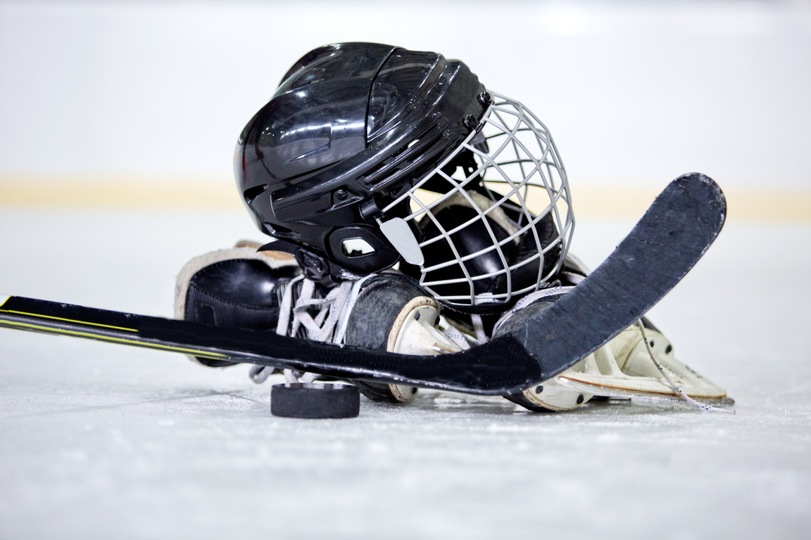 Hockey Helmet, Puck, Stick and Skates on Hockey Rink